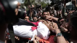 Pelayat membawa jasad seorang wartawan Palestina yang tewas ditembak tentara Israel saat meliput protes di perbatasan Gaza dengan Israel, Sabtu (7/4). Perusahaan media tempat Yasser Murtaja bekerja memastikan kematian wartawannya. (AP Photo/Khalil Hamra)