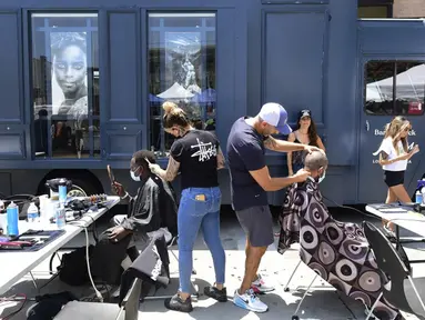 Cukur rambut gratis untuk para tunawisma ditawarkan dalam Los Angeles Mission di Los Angeles, California, Amerika Serikat, 12 Juli 2021. Aksi ini kerja sama penata rambut selebriti Jason Schneidman dari The Men's Groomer dengan The Barber Truck dan LA Mission. (Frederic J. BROWN/AFP)