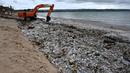 Dinas Lingkungan Hidup dan Kebersihan (DLHK) Kabupaten Badung, Bali menerjunkan sejumlah personel dan alat berat untuk membersihkan dan mengangkut sampah dari pantai Kedonganan. (SONNY TUMBELAKA/AFP)