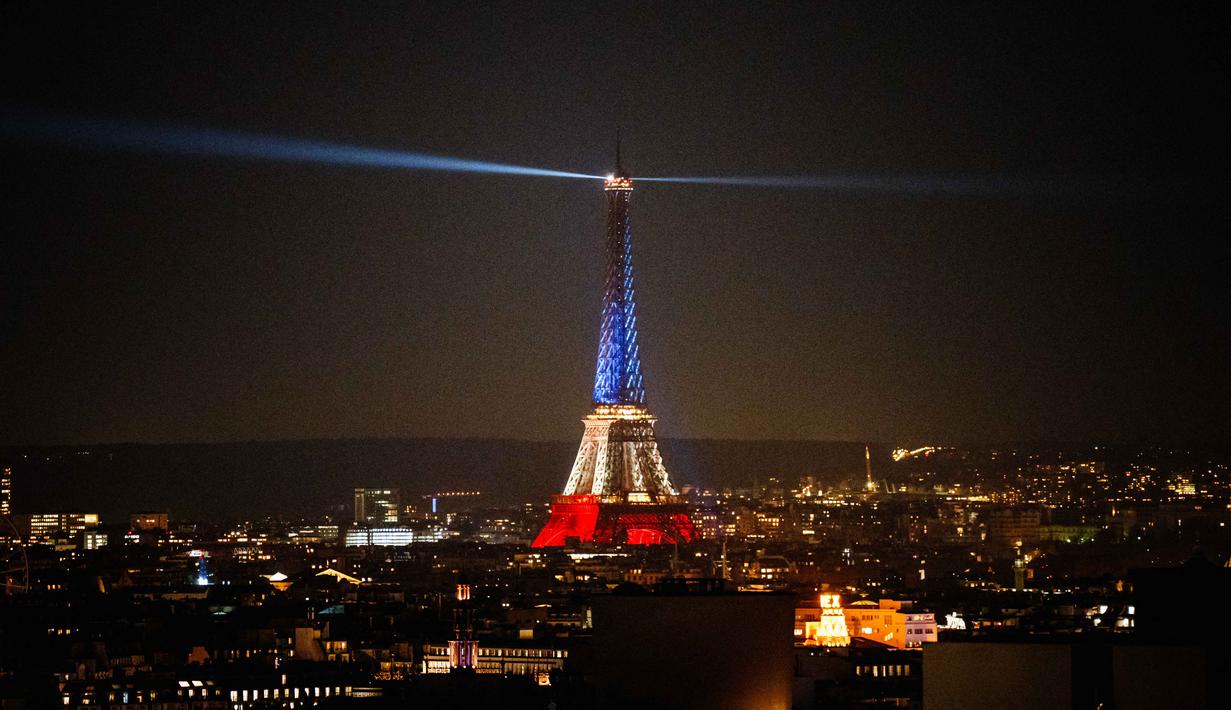 Ketika itu serangkaian serangan terjadi di sekitar ibu kota Prancis, termasuk di Stade de France, yang menewaskan 130 orang. Tampak sebuah foto yang menunjukkan Menara Eiffel yang diterangi dengan warna bendera nasional Prancis saat peringatan ke-10 serangan teroris Paris yang terjadi pada 2015, di Paris, pada 12 November 2025. (Dimitar DILKOFF/AFP)