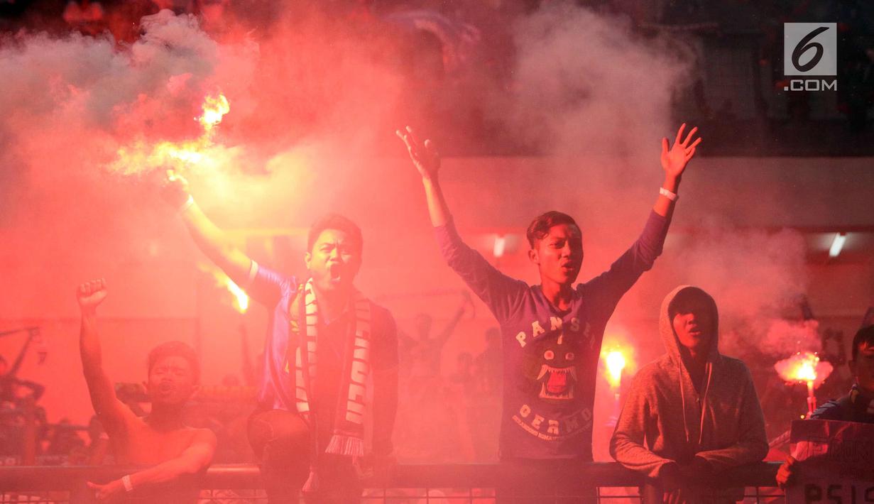 Suporter PSIS menyalakan suar saat merayakan kemenangan timnya melawan Martapura FC di Final tempat ketiga Liga 2 Indonesia di Stadion GBLA, Bandung, Selasa (28/11). PSIS unggul 6-4 dan lolos ke Liga 1 Indonesia. (Liputan6.com/Helmi Fithriansyah)