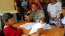 Seorang petugas Kantor Kelurahan Lenteng Agung, Jakarta, tampak melayani warga yang mengurus Kartu Pintar Jakarta (KJP), Rabu (4/6/14). (Liputan6.com/Miftahul Hayat)