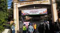 Akibat peristiwa ini, 54 siswa dikabarkan mengalami luka-luka. Tampak dalam foto, petugas kepolisian dan personel militer berjaga di gerbang SMAN 72 Jakarta pada Jumat 7 November 2025. (AP Photo/Dita Alangkara)