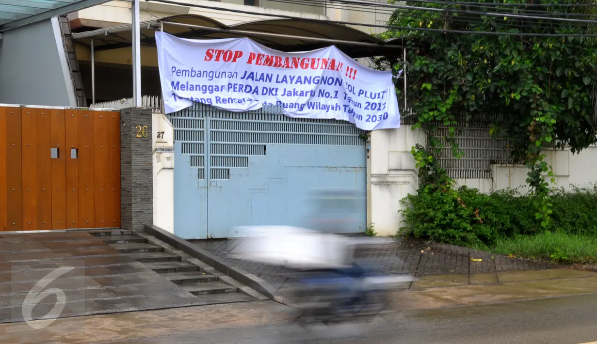Sebuah spanduk penolakan terpasang di depan rumah warga di kawasan perumahan Pluit, Jakarta, Kamis (17/12). Warga Pluit menolak rencana pembangunan jalan layang non tol yang masuk ke pemukiman mereka. (Liputan6.com/Faisal R Syam)