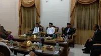Menteri Kesehatan Republik Indonesia Terawan Agus Putranto diberikan hadiah berupa baju koko berwarna putih dan peci hitam saat mengunjungi Pondok Pesantren yang ada di Gontor. (Liputan6.com/Giovani Dio Prasasti)