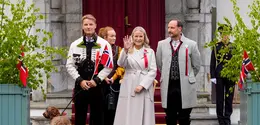 Putri Mahkota Norwegia Mette-Marit, Pangeran Mahkota Norwegia Haakon, dan Pangeran Norwegia Sverre Magnus menyapa pawai anak-anak selama perayaan hari nasional di Skaugum di Asker, dekat Oslo, Norwegia, pada 17 Mei 2026.  (dok. Lise Åserud / NTB / AFP)