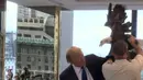 Salah satu kru mencoba membantu kandidat calon presiden AS, Donald Trump untuk menenangkan seekor burung elang botak saat sesi pengambilan foto di kantor Majalah TIME untuk nominasi dia sebagai Person of the Year, Kamis (10/12). (REUTERS/TIME Magazine)