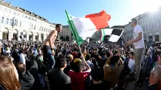 Suporter Juventus mengibarkan bendera Itali merayakan kemenangan usai merebut gelar Serie A Italia di pusat kota Turin, Italia (25/4). Juventus sukses meraih lima gelar juara Serie A dalam lima musim beruntun. (REUTERS/Giorgio Perottino) 