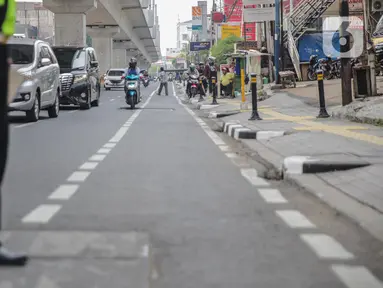 Petugas satlantas mensterilkan jalur sepeda di kawasan Blok A, Jakarta, Senin (25/11/2019). Mulai hari ini, polisi akan menilang para pengendara kendaraan bermotor yang nekat masuk dan melintas di jalur sepeda. (Liputan6.com/Faizal Fanani)