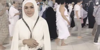 Yuni Shara berpose di depan Kabah mengenakan pakaian ihram. Untuk membawa perlengkapannya, ia mengenakan tas Gucci belt seharga sekitar Rp16 jutaan. (Dok. yunishara36)