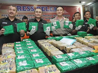 Jajaran DitTipid Narkoba Bareskrim Mabes Polri menunjukkan barang bukti sabu saat rilis di Jakarta, Kamis (21/12). Penyelundupan sabu dari Malaysia menggunakan modus dikemas plastik teh Cina warna kuning dan hijau. (Liputan6.com/Herman Zakharia)