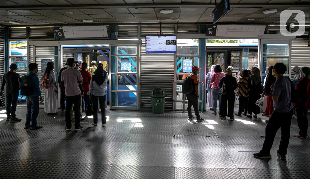 Antrean sejumlah calon penumpang saat akan menaiki bus Transjakarta di Halte Harmoni, Jakarta, Senin (10/1/2022). PT Transportasi Jakarta (Transjakarta) melakukan penyesuaian jam operasional usai ditetapkannya status PPKM menjadi Level 2 di Jakarta. (Liputan6.com/Faizal Fanani)