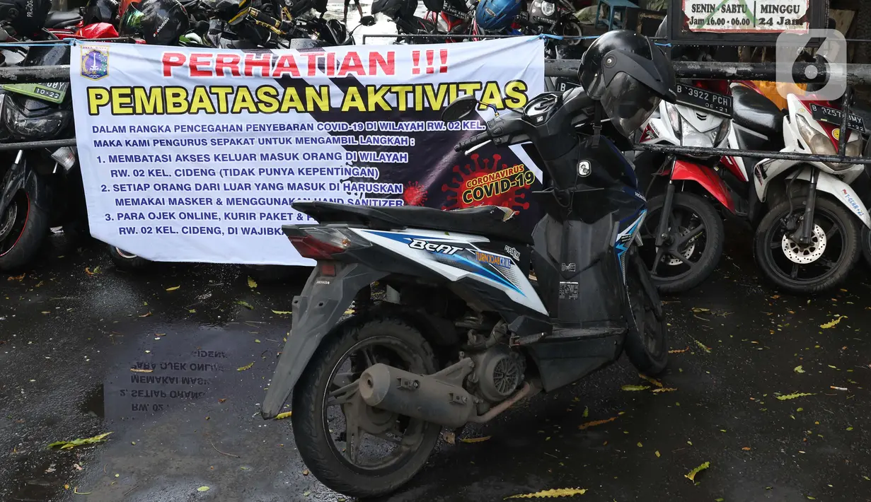 Spanduk tentang pembatasan aktivitas terpampang di pintu masuk perumahan di kawasan Cideng, Jakarta, Kamis (2/4/2020). Pemerintah menetapkan Pembatasan Sosial Berskala Besar dengan membatasi kegiatan tertentu penduduk di wilayah yang diduga terinfeksi COVID-19. (Liputan6.com/Helmi Fithriansyah)