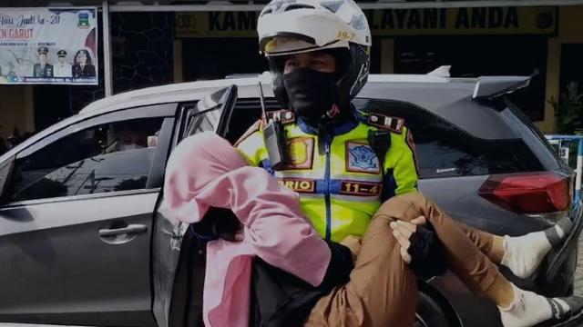 Kanit Gakum Satlantas Polres Garut Iptu Priyo Sambodo langsung turun menolong salah satu pemudik lansia yang membutuhkan pertolongan di jalur mudik nasional Limbangan, Garut. (Liputan6.com/Jayadi Supriadin)