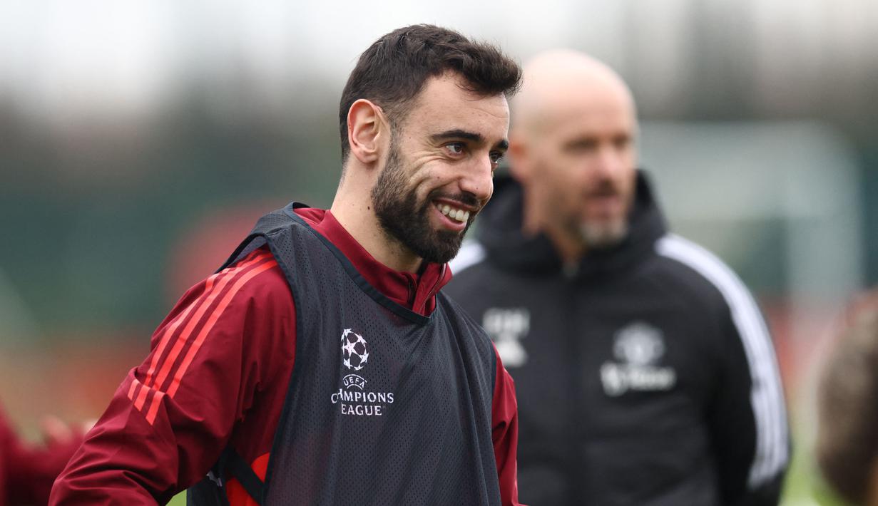 Senyum dari kapten tim MU, Bruno Fernandes, dalam sesi latihan yang berlangsung di Carrington, Manchester, Selasa (12/12/2023) dini hari WIB. (AFP/Darren Staples)