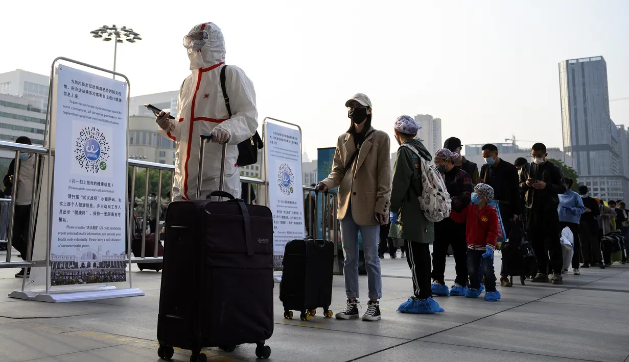 Warga yang mengenakan alat pelindung diri tiba di Stasiun Hankou, Wuhan, Hubei, China, Rabu (8/4/2020). Setelah pandemi virus corona COVID-19 mereda, banyak warga di Wuhan beraktivitas memakai masker, sarung tangan, pelindung wajah, hingga pakaian pelindung. (NOEL CELIS/AFP)