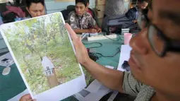 Seorang warga memperlihatkan gambar tapal batas yang dipasang pihak Taman Nasional Lore Lindu (TNLL) tepat di areal perkebunan milik warga, saat menggelar jumpa pers di Palu, Sulawesi Tengah, Selasa (17/4). (Antara)
