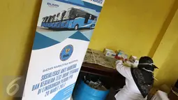 Seorang petugas sedang memproses tes urine di Pool Bus Perum PPD di Tangerang Selatan, Senin (20/3). Tes urine ini diikuti semua peserta yang terdiri dari direksi pejabat, staf dan pramudi/supir. (Liputan6.com/Helmi Afandi)