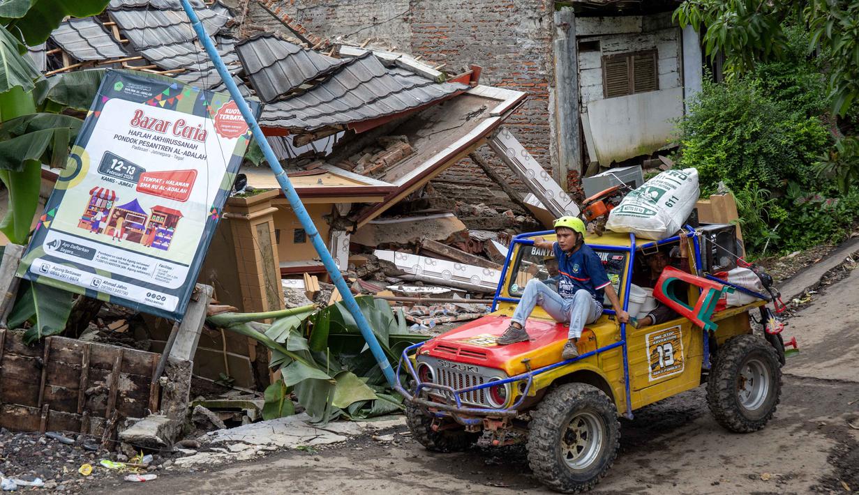 BNPB juga masih bersiaga di lokasi terdampak dan melakukan pendampingan kepada pemerintah daerah setempat serta menyalurkan dukungan bantuan logistik dan makanan. Tampak dalam foto, warga menyelamatkan barang-barang mereka setelah pergerakan tanah melanda permukiman mereka di desa Padasari, Tegal, Jawa Tengah, Senin 9 Februari 2026. (DEVI RAHMAN/AFP)