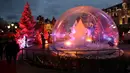 Orang-orang mengunjungi bola kaca raksasa dan dekorasi untuk menyambut Natal yang menghiasi depan Kasino Monte-Carlo di Monako pada 7 Desember 2018. (Photo by VALERY HACHE / AFP)