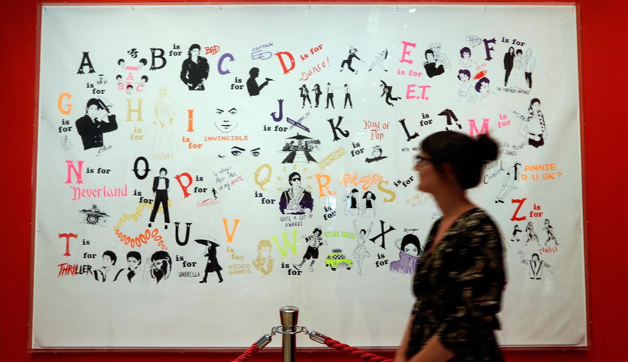 Seorang wanita mengamati karya seni Donald Urquhart pada pameran 'Michael Jackson: On The Wall' di National Potrait Gallery, London, Rabu (27/6). Pameran ini menggambarkan bagaimana Michael Jackson menginspirasi dunia seni. (AP/Kirsty Wigglesworth)