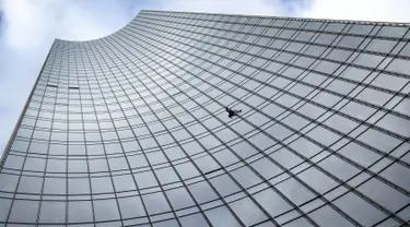 Pendaki kota Prancis, Alain Robert saat berusaha memanjat gedung XYZ di Frankfurt am Main, Sabtu (28/9/2019). Alain yang dikenal sebagai "The French Spiderman" kembali memanjat gedung tinggi di kota Jerman tersebut. (AFP Photo/Daniel Roland)