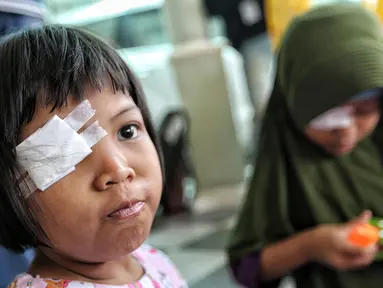 Seorang pasien anak diperban mata kanannya untuk mendapatkan bola mata palsu gratis di Klinik Ilyarsi Okularis, Villa Bintaro Indah, Tangsel, Selasa (15/5). Sebanyak 23 mata palsu dibagikan pada Gerakan 1.000 Mata Palsu Gratis. (Liputan6.com/Fery Pradolo)