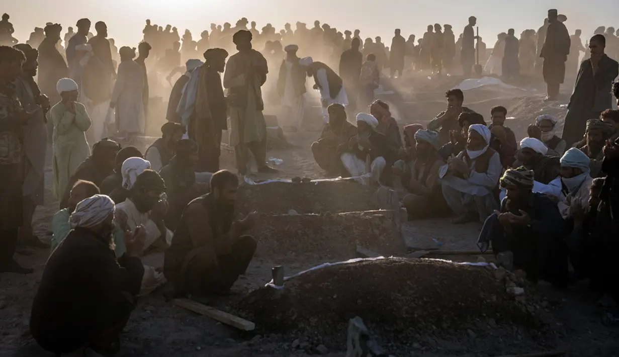 Warga memanjatkan doa saat memakamkan korban gempa Afghanistan secara massal di Distrik Zenda Jan, Provinsi Herat, sebelah barat Afghanistan, Senin (9/10/2023). (AP Photo/Ebrahim Noroozi)