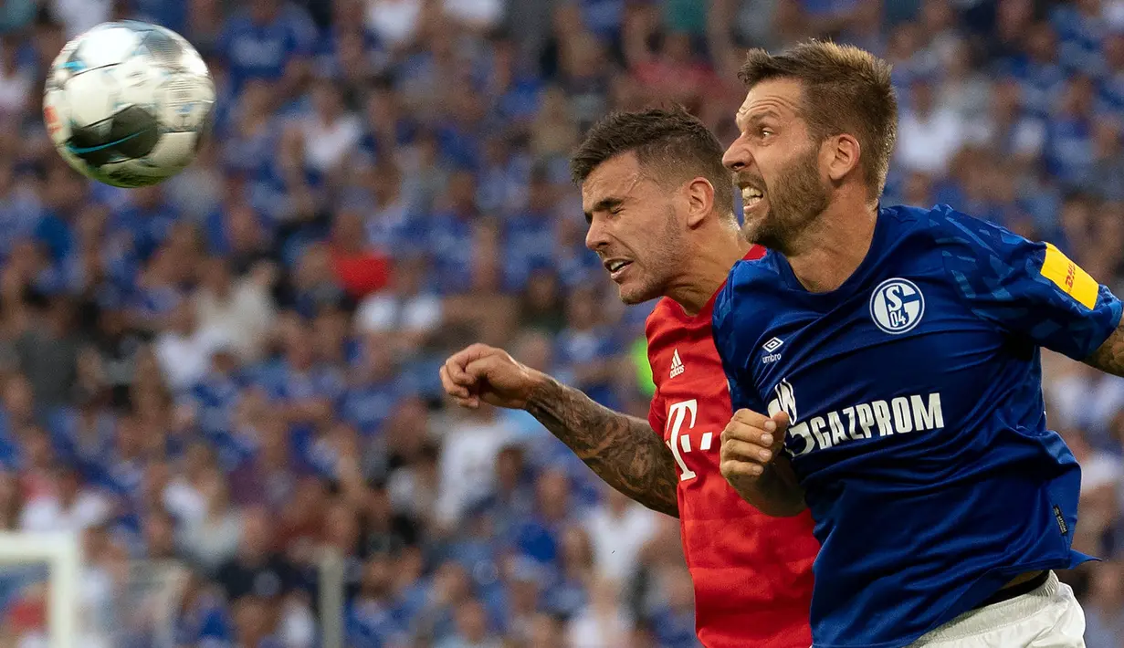 Bek Bayern Munchen, Lucas Hernandez, duel udara dengan striker Schalke, Guido Burgstaller, pada laga Bundesliga di Veltins-Arena, Gelsenkirchen, Sabtu (24/8). Schalke kalah 0-3 dari Munchen. (AFP/Federico Gabarini)