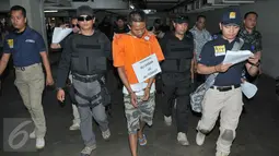 Ali Tomket berjalan menuju loket parkir saat reka ulang pembunuhan di Mall kawasan Senayan, Jakarta, Jumat (2/10/2015). Ali Tomket selain membunuh ia juga membawa kabur uang Rp 2,3 juta.(Liputan6.com/Andrian M Tunay)