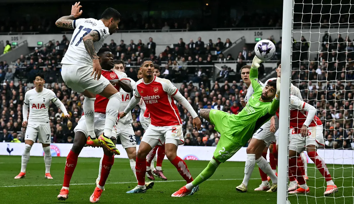 Kiper Arsenal, David Raya berusaha mementahkan bola hasil sundulan pemain Tottenham Hotspur, Cristian Romero pada laga lanjutan Liga Inggris 2023/2024 di Tottenham Hotspur Stadium, London, Inggris, 28 April 2024. (AFP/Ben Stansall)