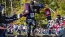 Troy dan Susan Wilson berjalan di atas tumpukan tanah selama North American Wife Carrying Championship di Sunday River Resort di Newry, Maine, pada 8 Oktober 2022. (Joseph Prezioso / AFP)