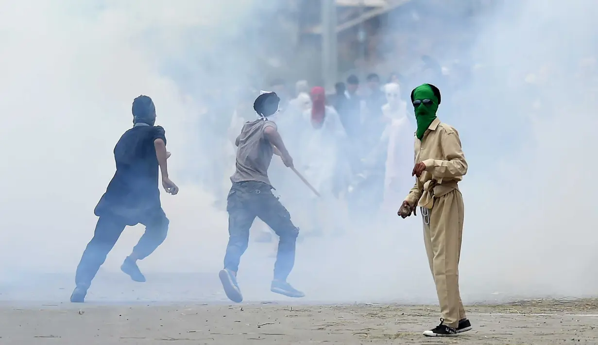Pemuda Kashmir saat bentrok dengan pasukan pemerintah India di pusat kota Srinagar (2/9). Bentrokan pecah setelah salat Idul Adha. Dimana pasukan polisi dan paramiliter menembaki para pemerotes di dekat tempat salat. (AFP Photo/Tauseef Mustafa)