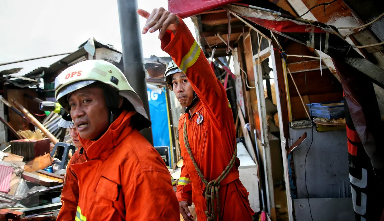 Petugas pemadam berusaha memadamkan api yang membakar ratusan rumah di Kampung Bandan, Ancol, Jakarta, Selasa (26/1). Api dengan cepat menjalar rumah warga yang terbuat dari kayu atau bedeng. (Liputan6.com/Faizal Fanani)