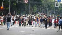 Pengunjuk rasa tolak UU Cipta Kerja bentrok dengan polisi di Kawasan Thamrin, Jakarta Pusat, Selasa (13/10/2020). Gas air mata ditembakkan ke arah pendemo yang melakukan perlawanan dengan melempar batu dan pecahan kaca. (merdeka.com/Imam Buhori)