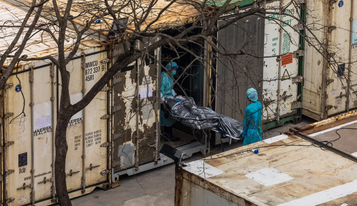 Pekerja memindahkan jenazah dari truk ke kontainer berpendingin di Rumah Sakit Umum Fu Shan, Hong Kong, Rabu (16/3/2022). Kasus COVID-19 terburuk yang melanda Hong Kong menimbulkan kepanikan serta membuat rumah sakit dan kamar jenazah penuh. (DALE DE LA REY/AFP)