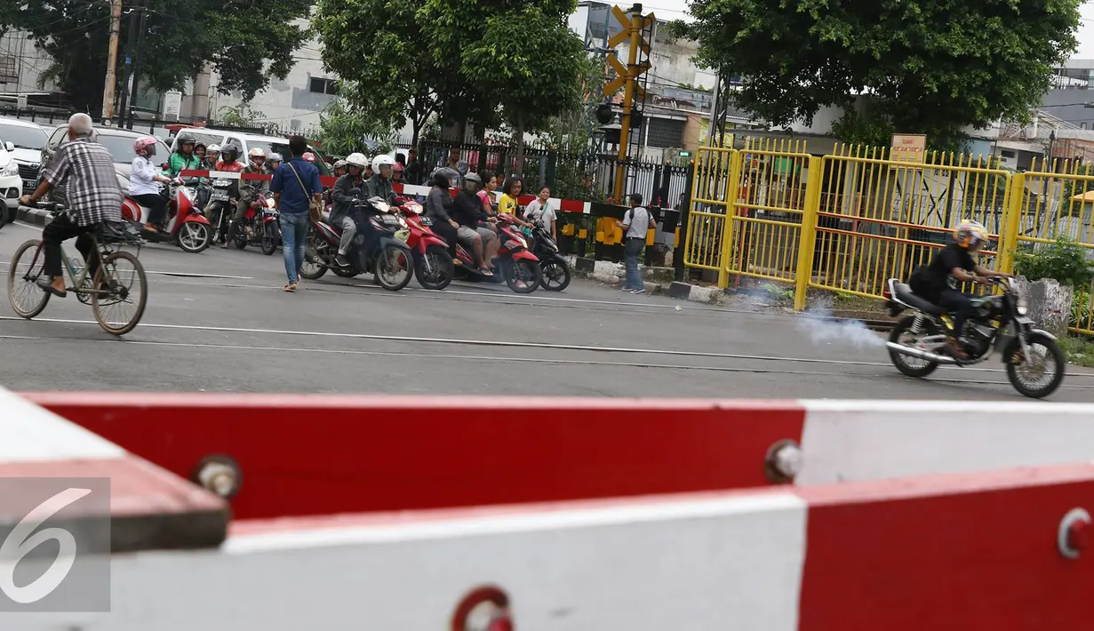 Aksi nekat terobos palang pintu yang dilakukan oleh beberapa pengendara motor di Kemayoran, Jakarta, Kamis (6/10). Walau palang pintu sudah menghalangi namun mereka tetap berusaha menerobosnya. (Liputan6.com/Immanuel Antonius)