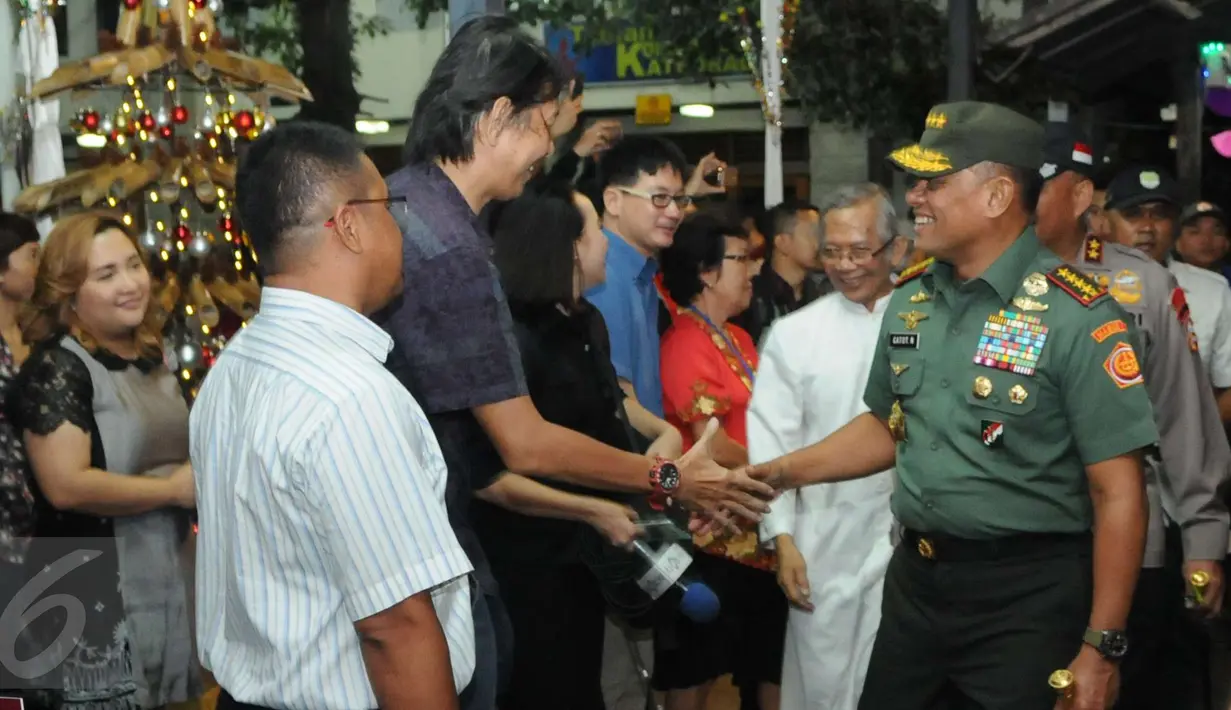 Panglima TNI Gatot Nurmantyo bersalaman dengan salah satu jemaat saat meghadiri misa natal di Gereja katedral, Jakarta, Sabtu (24/12). Kedatangannya unutk mengecek keamanan dan mengucapkan natal secara langsung kegereja. (Liputan6.com/Helmi Afandi)