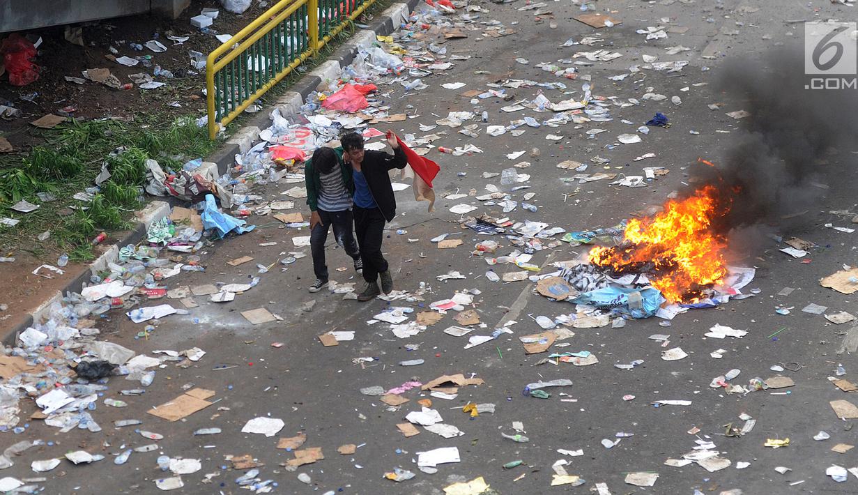Mahasiswa menyelamatkan diri saat terjadi bentrok dalam demonstrasi menolak pengesahan RUU KUHP dan revisi UU KPK di depan Gedung DPR, Jakarta, Selasa (24/9/2019). Dua polisi dan tiga mahasiswa dilaporkan terluka dalam demonstrasi tersebut. (merdeka.com/Arie Basuki)