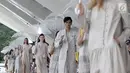 Model membawa payung saat memeragakan busana rancangan desainer Sapto Djojokartiko di Jakarta, Kamis (20/9). Sapto memamerkan 70 busana Spring/Summer 2019 untuk merayakan 10 tahun karyanya di dunia fesyen. (Liputan6.com/Herman Zakharia)