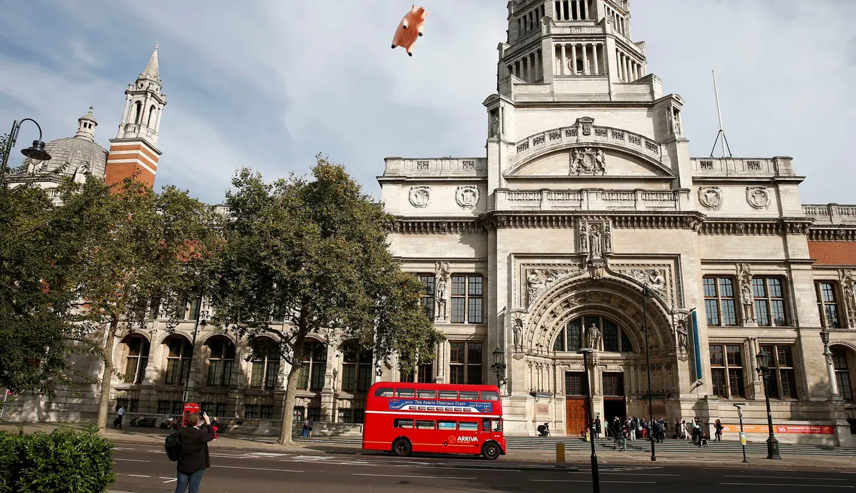 Warga mengambil gambar balon berbentuk babi yang melayang di atas Victoria and Albert Museum di London, Rabu (31/8). Balon babi milik Pink Floyd itu untuk mempromosikan acara "The Pink Floyd Exhibition: Their Mortal Remains". (REUTERS/Peter Nicholls)