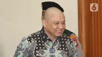 Teddy masuk ke ruang sidang dengan mengenakan baju batik biru hitam. (Liputan6.com/Herman Zakharia)