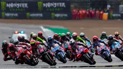 Balapan sprint MotoGP Grand Prix Inggris yang digelar di Sirkuit Silverstone pada Sabtu (3/8/2024) malam WIB langsung diwarnai crash di putaran pertama ketika balapan dimulai. Kala Marco Bezzecchi dan Franco Morbidelli terjatuh. (BENJAMIN CREMEL/AFP)