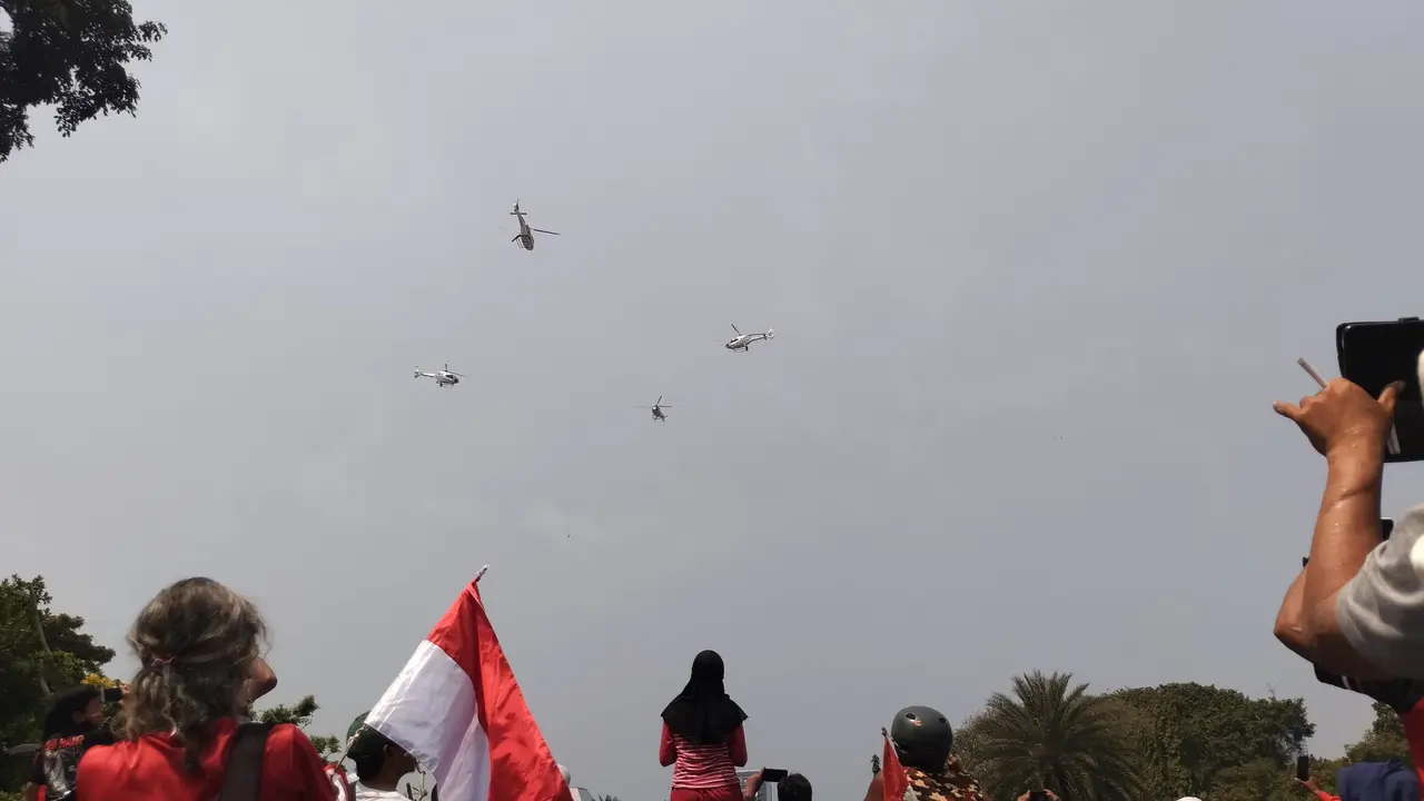 Warga di luar Istana Merdeka menyaksikan atraksi pesawat dan helikopter TNI-Polri dalam peringatan HUT ke-78 RI.