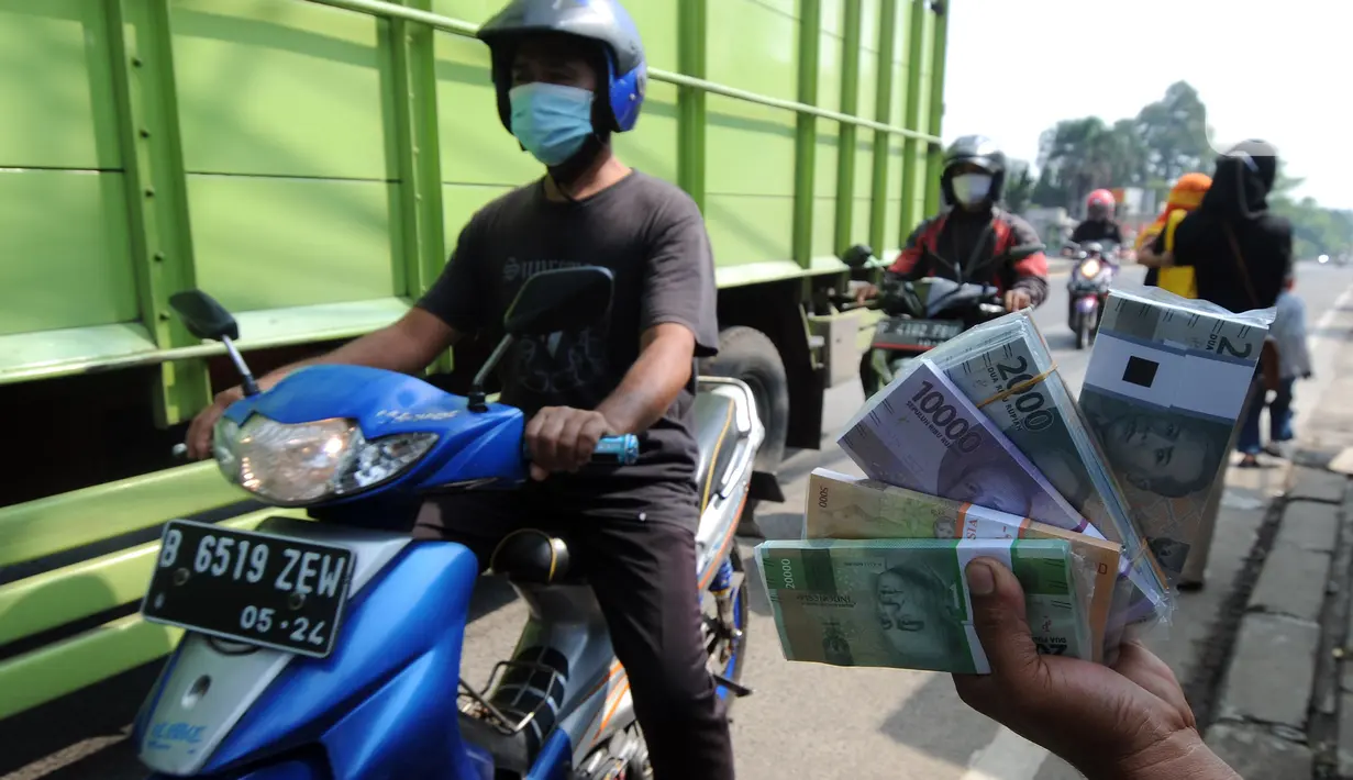 Penjual jasa penukaran uang menawarkan uang baru di kawasan Jalan Raya Parung, Bogor, Jawa Barat, Jumat  (7/5/2021). Penjual jasa penukaran uang memungut tambahan biaya sebesar 5 sampai 10 persen dari jumlah uang yang ditukarkan. (merdeka.com/Arie Basuki)