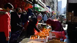 Orang-orang membeli bahan makanan dan berjalan-jalan di kawasan Chinatown di New York City, 5 Februari 2021. Tahun Baru Imlek akan jatuh Jumat depan, 12 Februari, dan itu harusnya menjadi waktu tersibuk untuk Chinatown, tetapi tidak pada tahun 2021 saat pandemi COVID-19 mewabah. (Angela Weiss/AFP)