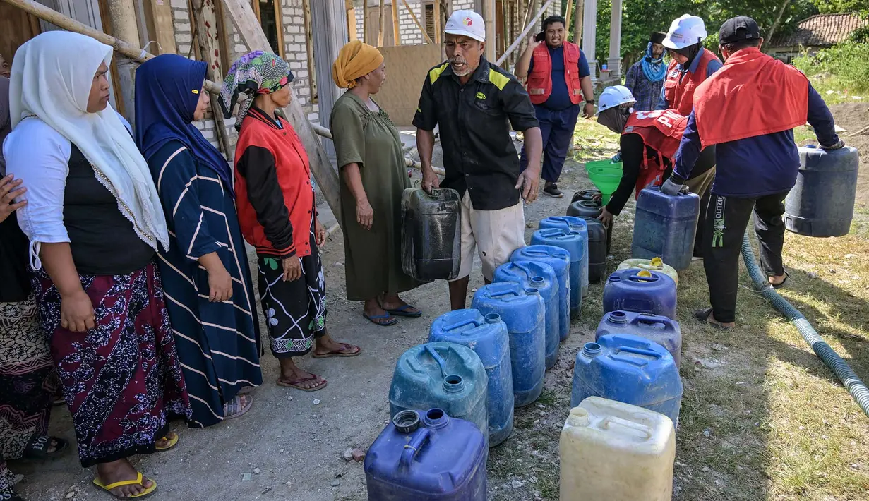 Warga antri saat pendiistribusian air bersih oleh Palang Merah Indonesia (PMI) Kabupaten Bangkalan di Dusun Batangan Tengah, Desa Batangan, Kecamatan Tanah Merah, Kabupaten Bangkalan, Jawa Timur, Selasa (21/7/2026). (AFP/ Juni Kriswanto)