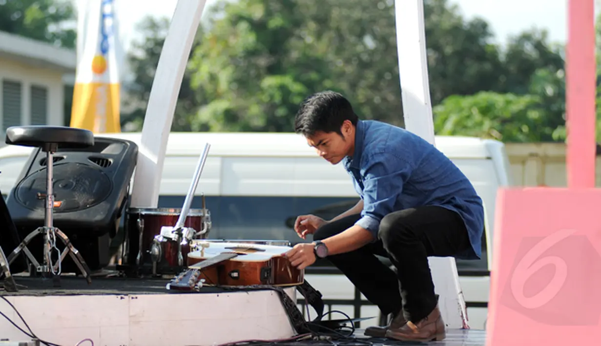 Pemenang kedua Music Video Contest, Dibya Dika menyiapkan gitar jelang beraksi di panggung inBox di Cibinong Square, Bogor, Kamis (29/1). Dibya Dika merupakan pemenang kedua Music Video Contest yang digelar Vidio.com. (Liputan6.com/Helmi Fithriansyah)