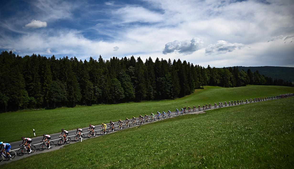 Rombongan pebalap melintasi padang rumput hijau di Swiss selama etape ke-8 pada ajang balapan sepeda Tour de France 2022. (AFP/Anne-Christine Poujoulat)