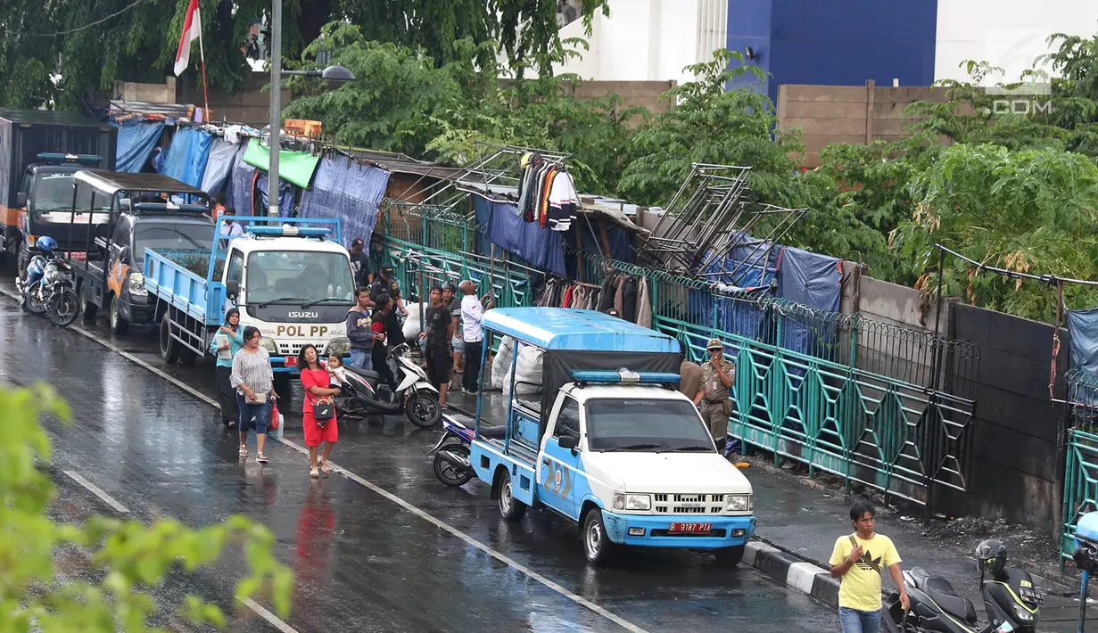 Personel Satpol PP berjaga di sekitar trotoar kawasan Senen, Jakarta, Kamis (22/11). Penjagaan itu menyebabkan trotoar di kawasan Senen bebas dari PKL yang biasa berjualan pakaian bekas. (Liputan6.com/Immanuel Antonius)